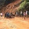 Lực lượng tại chỗ huyện Xín Mần giúp người dân di chuyển phương tiện qua các điểm sạt lở. (Ảnh: Kim Tiến/TTXVN phát)
