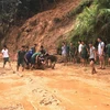 Lực lượng tại chỗ huyện Xín Mần giúp người dân di chuyển phương tiện qua các điểm sạt lở. (Ảnh: Kim Tiến/TTXVN phát)