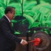 Phó Thủ tướng Thường trực Chính phủ Trương Hòa Bình đánh chiêng tại Lễ khai trương Khu gian hàng quốc gia tại Hội chợ Trung Quốc-ASEAN. (Ảnh : Lê Trung Kiên/TTXVN)