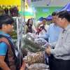 Phó Chủ tịch UBND tỉnh Quảng Nam Lê Trí Thanh đi kiểm tra hàng hóa tại hội chợ. (Ảnh: Nguyễn Sơn/TTXVN)