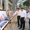 Bộ trưởng Bộ Thông tin và Truyền thông Trương Minh Tuấn và cán bộ, phóng viên TTXVN tham quan trưng bày ảnh Tuần lễ Cấp cao APEC 2017. (Ảnh: Doãn Tấn/TTXVN)