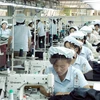 Công nhân làm việc tại một nhà máy dệt may của Triều Tiên trong khu công nghiệp Kaesong ngày 22/5/2007. (Nguồn: AFP/TTXVN)