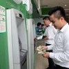 Khách hàng giao dịch tại điểm thanh toán thẻ ATM Ngân hàng VPBank. (Ảnh: Trần Việt/TTXVN)