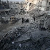 Tìm kiếm các nạn nhân sau một vụ không kích xuống Hamouria, Đông Ghouta ngày 9/1. (Nguồn: AFP/TTXVN) 