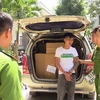 Lực lượng công an khám xét đối tượng vận chuyển hàng lậu. (Ảnh: Nguyễn Văn Việt/TTXVN)