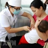 Nhân viên y tế tiêm phòng cho trẻ tại Hà Nội. (Ảnh: TTXVN)