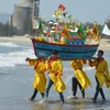Nhân dân tại khu dân cư văn hóa biển Kim Liên làm lễ rước, thả thuyền. Ảnh: Đinh Văn Nhiều/TTXVN)