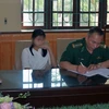 Lực lượng chức năng tiến hành bàn giao 2 nạn nhân cho gia đình. (Ảnh: Nguyễn Hoàng/TTXVN)