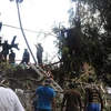 Lực lượng cứu hộ tìm kiếm các nạn nhân tại hiện trường máy bay rơi. (Nguồn: THX/TTXVN)