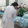 Bác sỹ thăm khám và điều trị cho công nhân trong một vụ nghi ngộ độc thức ăn. (Ảnh: Nguyễn Văn Việt/TTXVN)