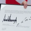 Văn kiện chung lưu lại chữ ký của Tổng thống Mỹ Donald Trump (trái) và của nhà lãnh đạo Triều Tiên Kim Jong-un (phải) tại Sentosa, Singapore ngày 12/6. (Nguồn: AFP/TTXVN)