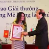 Nhà thơ Hữu Thỉnh, Chủ tịch Hội Nhà văn Việt Nam trao thưởng cho tác giả đạt Giải thưởng Văn học sông Mekong lần thứ 9. (Ảnh: Thanh Tùng/TTXVN)