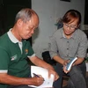Cựu chiến binh, nhà báo Trịnh Phi Long (trái) trao đổi kinh nghiệm nghề báo với phóng viên TTXVN. (Ảnh: Xuân Khu/TTXVN)