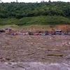 Do mưa lớn, nước dâng cao, bùn đất và rác từ các nơi đổ về nên việc tìm kiếm thi thể em Hoàng Thị Nhàn gặp nhiều khó khăn. (Nguồn: TTXVN)