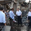 Đại sứ Vũ Quang Minh (thứ hai từ phải sang) đến thị sát và thăm hỏi kiều bào sau vụ cháy. (Ảnh: TTXVN)