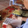 Sau nhiều năm theo học, các lão sinh có thể viết chữ Hán Nôm thành thạo. (Ảnh: Nguyễn Thảo/TTXVN)