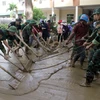 Lực lượng công an, bộ đội, giáo viên và phụ huynh học sinh tổng dọn vệ sinh tại trường Tiểu học thị trấn Mường Xén sau khi nước lũ rút. (Ảnh: Tá Chuyên/TTXVN)