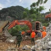 Ủy ban Nhân dân huyện Con Cuông huy động phương tiện, lực lượng khẩn cấp cứu cây cầu. (Ảnh: TTXVN)