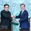 Nhà lãnh đạo Triều Tiên Kim Jong-un (trái) và Tổng thống Hàn Quốc Moon Jae-in ký kết Tuyên bố Panmunjom hôm 27/4. (Nguồn: THX/TTXVN)