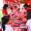 Các bạn học sinh tại Hệ thống trường Hội nhập Quốc tế iSchool hào hứng xem và chọn sách. (Ảnh: Vietnam+)