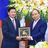 Thủ tướng Nguyễn Xuân Phúc tặng quà lưu niệm cho Thủ tướng Lào Thongloun Sisoulith. (Ảnh: Thống Nhất/TTXVN)