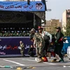 Binh sỹ Iran chuyển nạn nhân bị thương trong vụ tấn công nhằm vào lễ diễu binh ở thành phố Ahvaz. (Ảnh: AFP/TTXVN)
