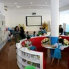Học sinh đọc sách, vui chơi trong thư viện Trường Tiểu học Phan Văn Trị do Chủ tịch nước Trần Đại Quang và các đại biểu Quốc hội Thành phố Hồ Chí Minh tặng. (Ảnh: Tiến Lực/TTXVN)