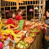 Người dân tham quan và mua món ăn tại các gian hàng ẩm thực. (Ảnh: Thành Đạt/TTXVN)
