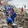 Người dân dọn dẹp đống đổ nát do bão Yutu tại Manila, Philippines ngày 30/10/2018. (Ảnh: AFP/TTXVN)