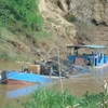 Nhiều đối tượng lén lút khai thác trái phép trên sông Đồng Nai thời gian qua dẫn đến tình trạng bờ sông bị sạt lở nghiêm trọng. (Ảnh: Đậu Tất Thành/TTXVN)