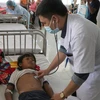 Các bác sỹ tại Bệnh viện Nhi tỉnh Gia Lai thăm khám cho em Đinh Đang bị ngộ độc do ăn thịt cóc. (Ảnh: Dư Toán/TTXVN)