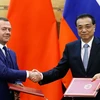 Thủ tướng Trung Quốc Lý Khắc Cường (phải) và Thủ tướng Nga Dmitry Medvedev (trái) tại lễ ký các thỏa thuận hợp tác song phương ở Bắc Kinh, Trung Quốc ngày 7/11/018. (Ảnh: AFP/TTXVN)