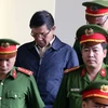 Lực lượng chức năng dẫn giải bị cáo Phan Văn Vĩnh vào tòa. (Ảnh: Trung Kiên/TTXVN)