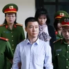 Lực lượng chức năng đưa bị cáo Phan Sào Nam vào tòa. (Ảnh: Trung Kiên/TTXVN)