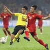 Phan Văn Đức tranh bóng với hậu vệ Malaysia. (Ảnh: Hoàng Linh/TTXVN)