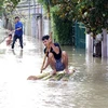 Người dân xã Tam An, huyện Phú Ninh, tỉnh Quảng Nam vẫn bị ngập sâu trong nước. (Ảnh: Đỗ Văn Trưởng/TTXVN)