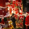 Du khách tham quan và chọn mua các mặt hàng trang trí đón Giáng sinh trên phố Hàng Mã. (Ảnh: Hoàng Hùng/TTXVN)
