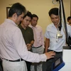 Đại diện Công ty Lascitec giới thiệu về thiết bị phẫu thuật ứng dụng công nghệ laser vi điểm do kỹ sư Việt Nam thiết kế, chế tạo. (Ảnh: Tiến Lực/TTXVN)