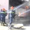 Lực lượng chữa cháy tích cực khống chế ngọn lửa. (Ảnh: Nguyễn Văn Việt/TTXVN)