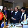 Thủ tướng Nguyễn Xuân Phúc và các đại biểu thăm các gian hàng trưng bày tại hội nghị. 