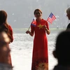 Thiếu nữ mặc áo dài in Quốc kỳ Việt Nam, cầm cờ Mỹ và Triều Tiên chào mừng Hội nghị ở khu vực hồ Hoàn Kiếm. (Ảnh: Lâm Khánh/TTXVN)