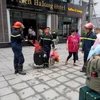 Lực lượng phòng cháy chữa cháy giải cứu khách du lịch Trung Quốc mắc kẹt tại đám cháy. (Ảnh: TTXVN)