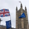 Cờ EU (phải) và quốc kỳ Anh (trái, phía trên) bên ngoài tòa nhà Quốc hội Anh ở London ngày 6/3 vừa qua. (Ảnh: THX/TTXVN)