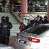Cảnh sát dẫn giải Đoàn Thị Hương ra xe ôtô sau phiên toà. (Ảnh: Hà Ngọc/TTXVN)