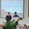 Sinh viên Nguyễn Hoàng Minh Vũ nhận khen thưởng đột xuất của UBND tỉnh Đồng Nai. (Ảnh: Lê Xuân/TTXVN)