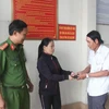 Chị Lê Thị Hậu trao trả lại tài sản cho người đánh rơi tại Công an phường Thanh Bình, thành phố Biên Hòa. (Ảnh: Sỹ Tuyên/TTXVN)