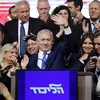 Thủ tướng Israel Benjamin Netanyahu (giữa) vẫy chào những người ủng hộ sau khi kết quả bầu cử được công bố, tại trụ sở đảng Likud ở Tel Aviv, ngày 10/4. (Ảnh: AFP/TTXVN)