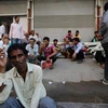 Người dân chờ được thuê làm ngồi bên vệ đường ở Mumbai của Ấn Độ. (Nguồn: Reuters)