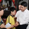 Chủ tịch UBND thành phố Hà Nội Nguyễn Đức Chung thăm hỏi, động viên gia đình chị Lê Thị Thu Hà. (Ảnh: Lâm Khánh/TTXVN)