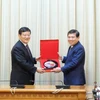 Chủ tịch UBND Thành phố Hồ Chí Minh Nguyễn Thành Phong trao quà lưu niệm cho ông Từ Lạc Giang. (Ảnh: Xuân Khu/TTXVN)